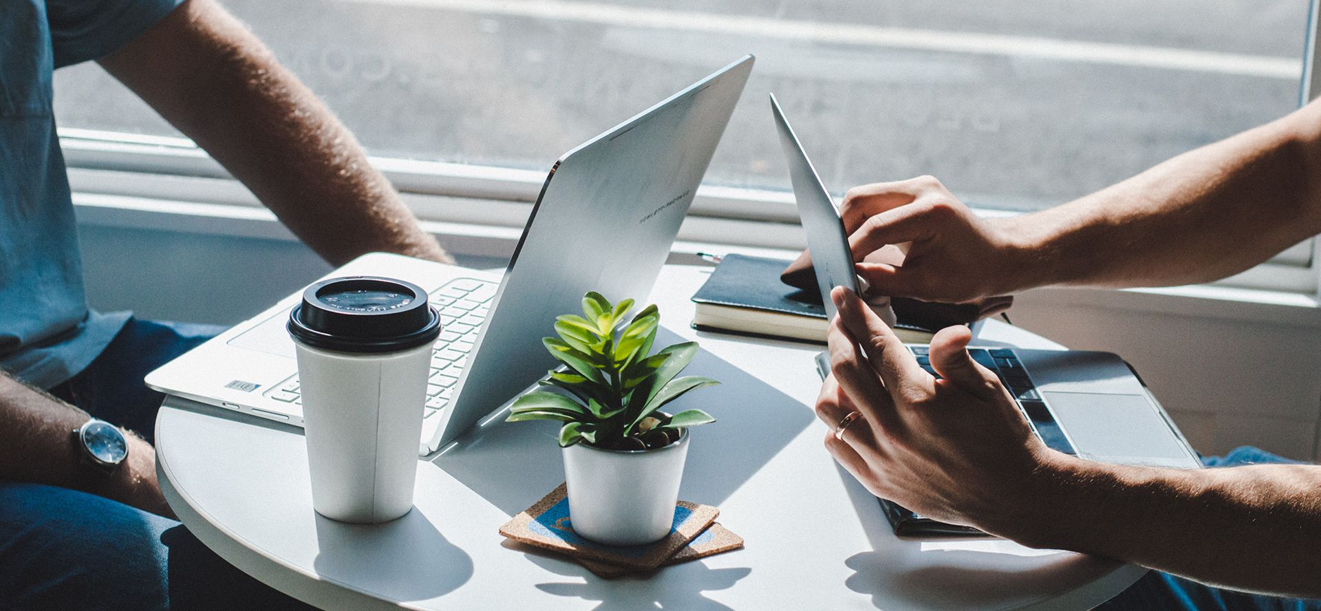 two people sitting at table with laptops