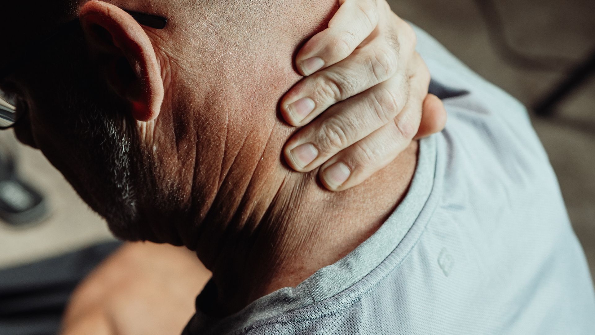 man holding back of head