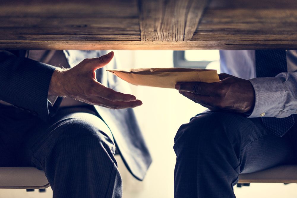 Business people sending documents under the table