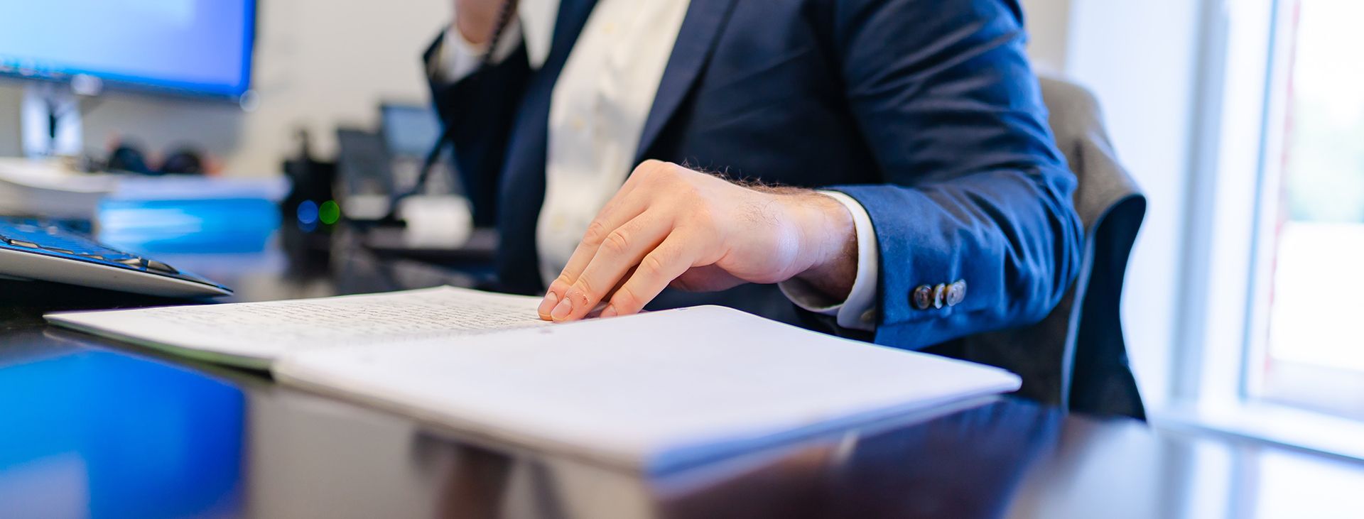 person at desk on phone with documents