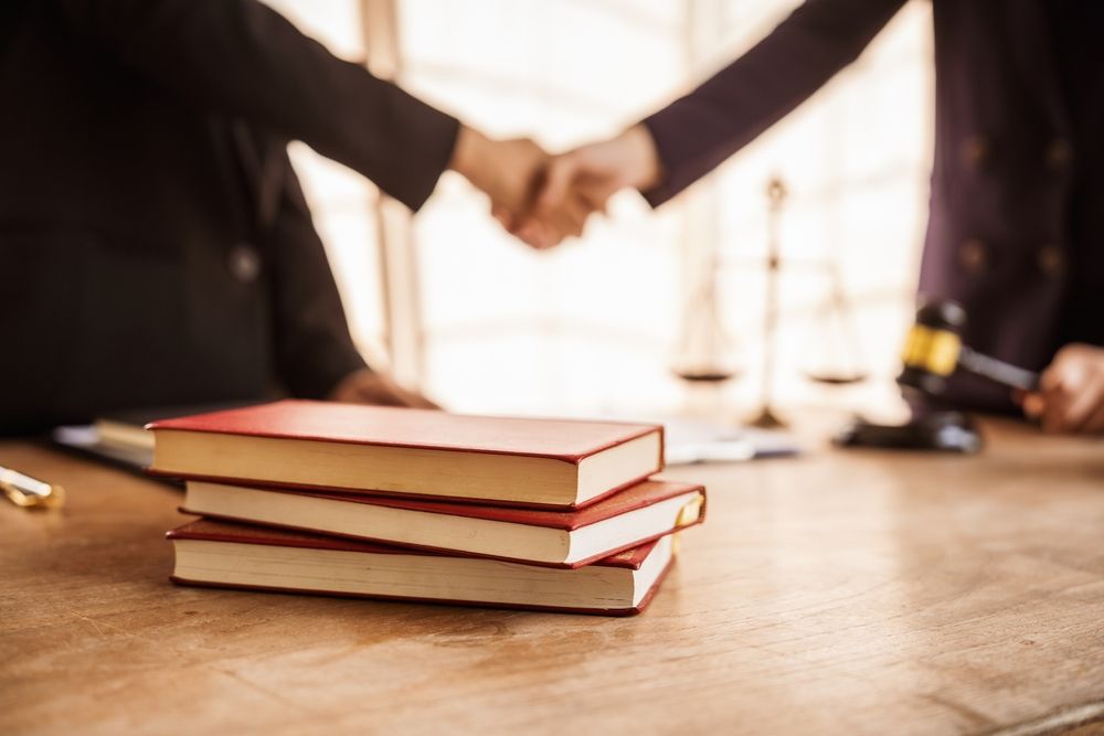 Shaking hands, Lawyers offer legal guidance, stand for clients in court, and aid with legal paperwork. analyze laws to safeguard clients' rights and interests, fair representation and justice.