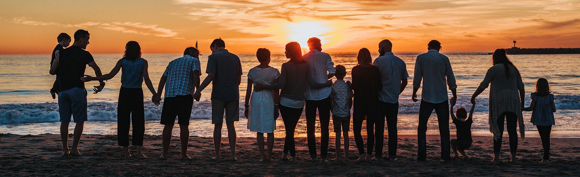 family on beach at sunset