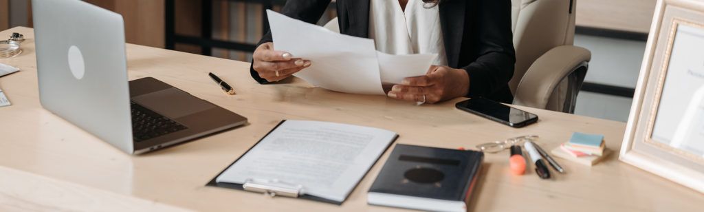 person reviewing paperwork at desk