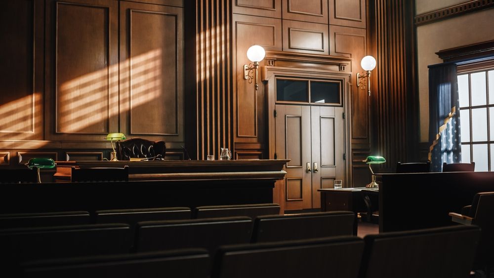 Empty courtroom with rows of wooden benches